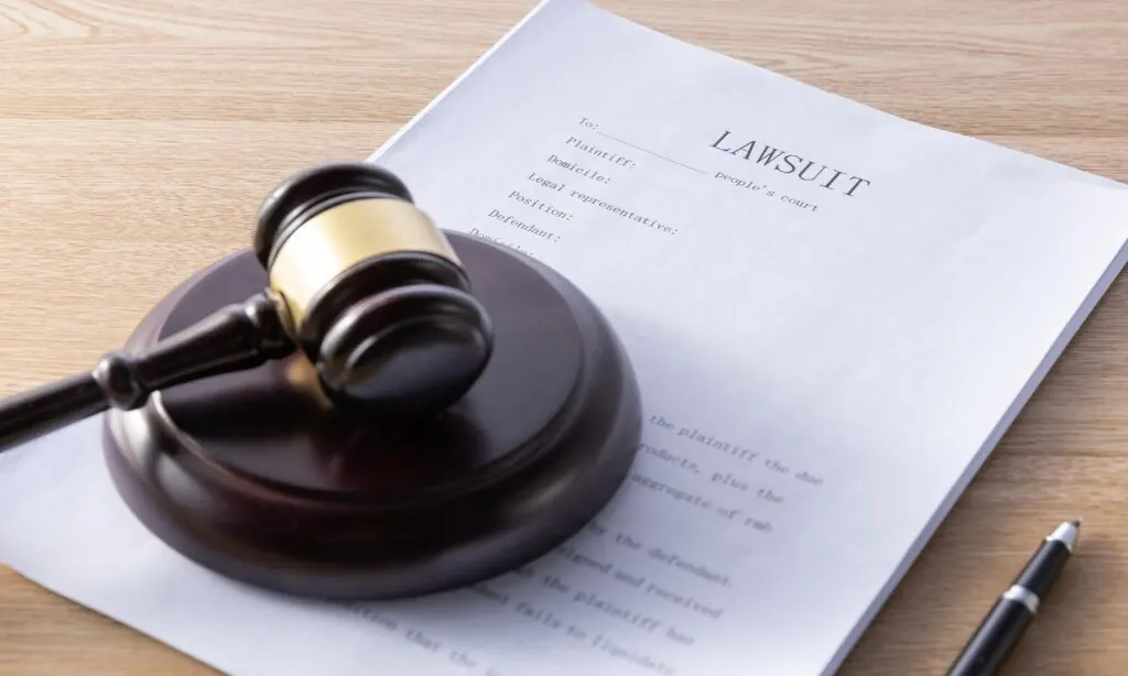 Demanda judicial y mazo sobre un escritorio
