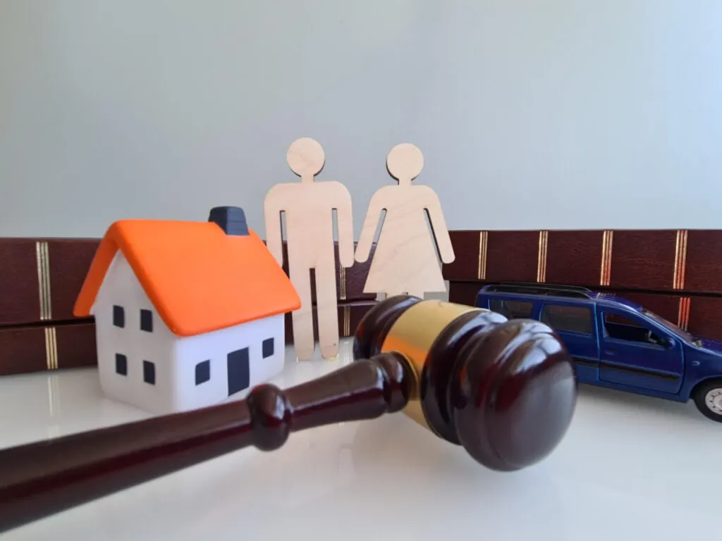 Figuras de una pareja, una casa y un mazo de juez