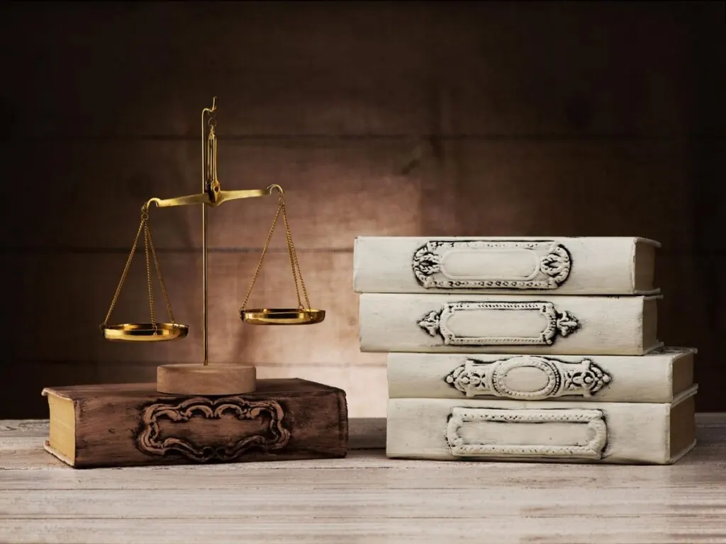 Balanza de la justicia junto a libros de derecho