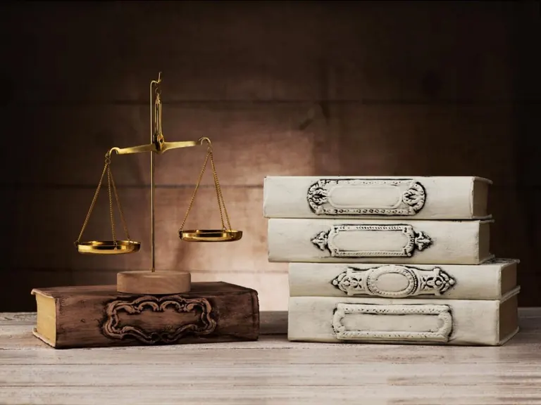 Balanza de la justicia junto a libros de derecho